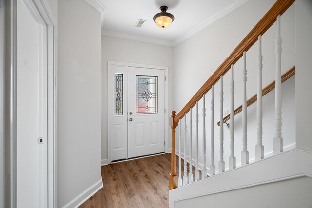 foyer entrance with light wood-type flooring and crown molding