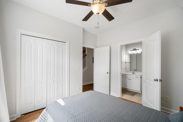 bedroom with sink, light tile patterned floors, a closet, ceiling fan, and ensuite bathroom