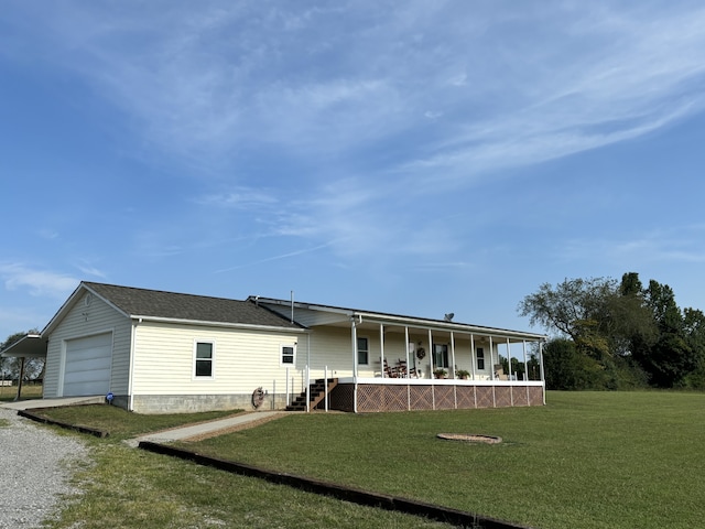 rear view of house featuring a yard, a garage, and covered porch