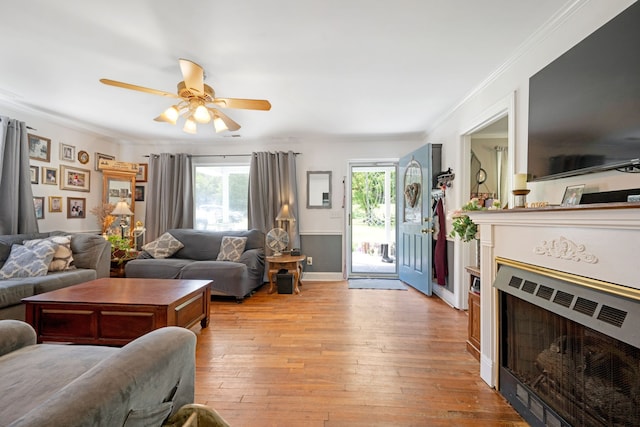 living room with crown molding, ceiling fan, and light hardwood / wood-style floors