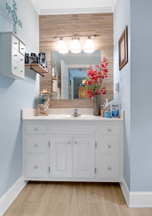 bathroom featuring hardwood / wood-style floors, vanity, and ornamental molding