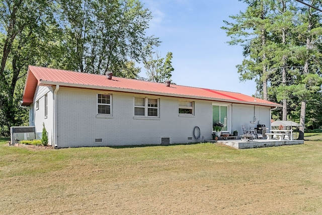 rear view of house with a lawn and a patio