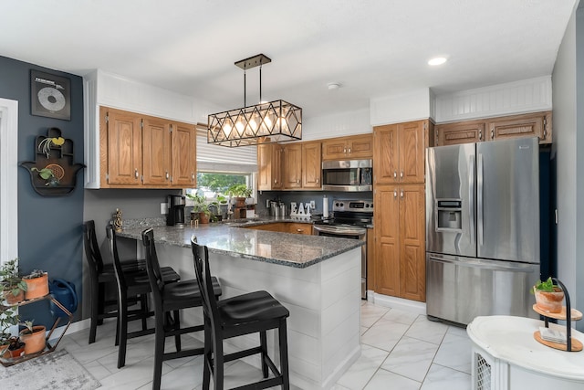 kitchen featuring dark stone counters, appliances with stainless steel finishes, light tile patterned floors, sink, and kitchen peninsula