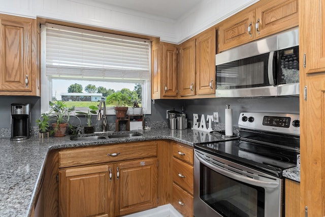 kitchen featuring range, sink, and dark stone countertops