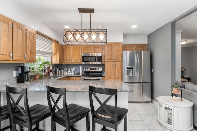 kitchen with appliances with stainless steel finishes, sink, light tile patterned floors, kitchen peninsula, and a breakfast bar