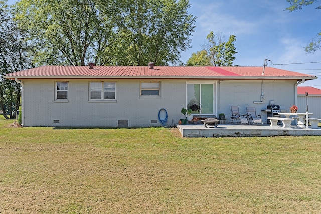 back of property featuring a patio and a lawn