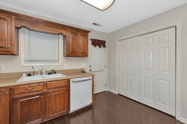 kitchen with sink, dark hardwood / wood-style flooring, and white dishwasher