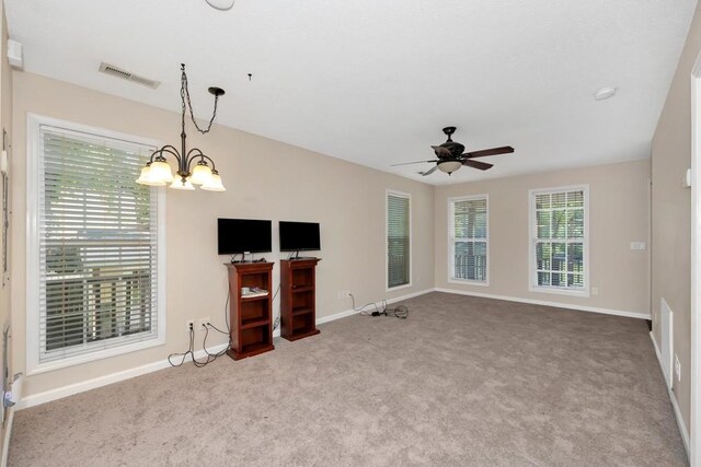 interior space with light carpet and ceiling fan with notable chandelier