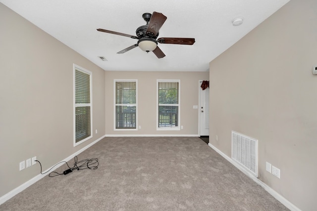 carpeted spare room featuring ceiling fan