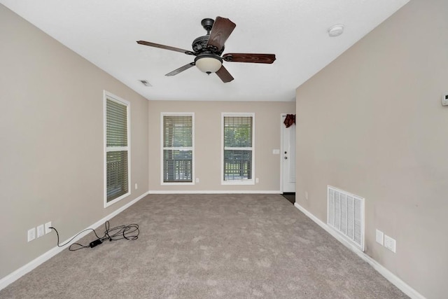 unfurnished room featuring ceiling fan, light colored carpet, visible vents, and baseboards