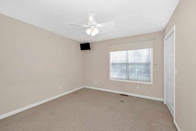 unfurnished room with light carpet, ceiling fan, and baseboards