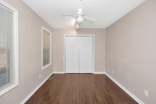 unfurnished bedroom featuring ceiling fan, a closet, and hardwood / wood-style floors