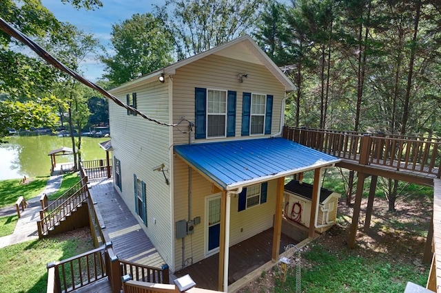 back of property featuring stairs, metal roof, and a deck with water view