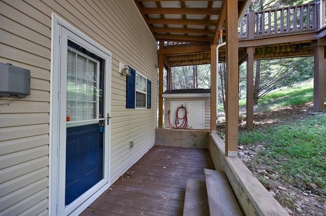 wooden terrace featuring an outdoor structure and a storage shed