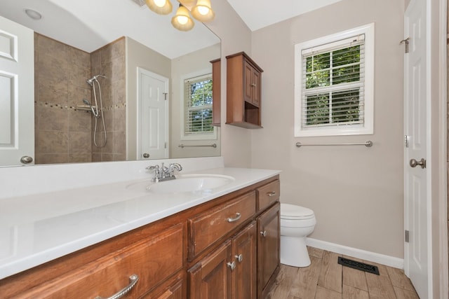 bathroom with plenty of natural light, vanity, hardwood / wood-style floors, and toilet