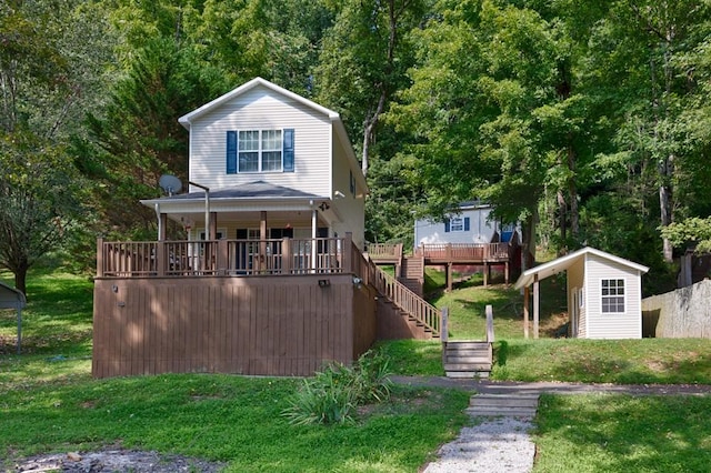 view of front facade featuring a shed, stairway, an outdoor structure, and a front yard