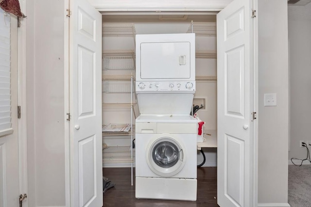 clothes washing area with laundry area, dark wood finished floors, and stacked washer / drying machine