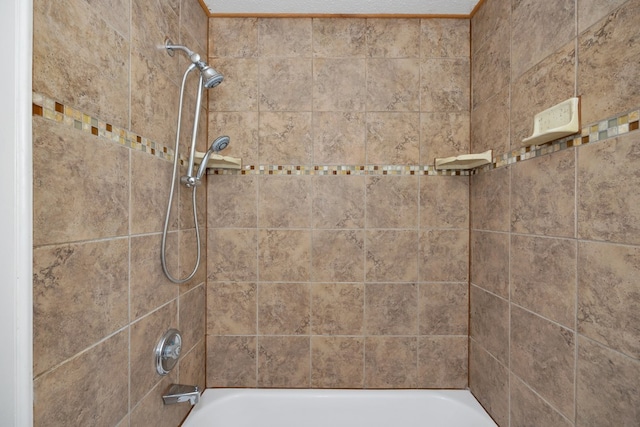 bathroom featuring tiled shower / bath and a textured ceiling