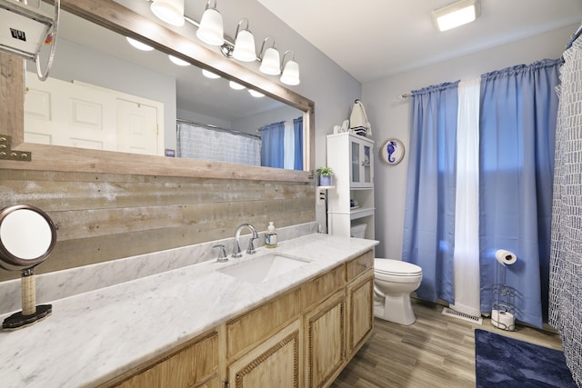 bathroom featuring vanity, toilet, and hardwood / wood-style floors