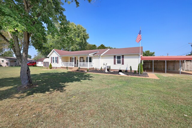 view of front facade with covered porch, a carport, and a front lawn