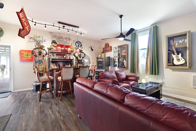 living room featuring a healthy amount of sunlight, bar area, ceiling fan, and dark hardwood / wood-style floors