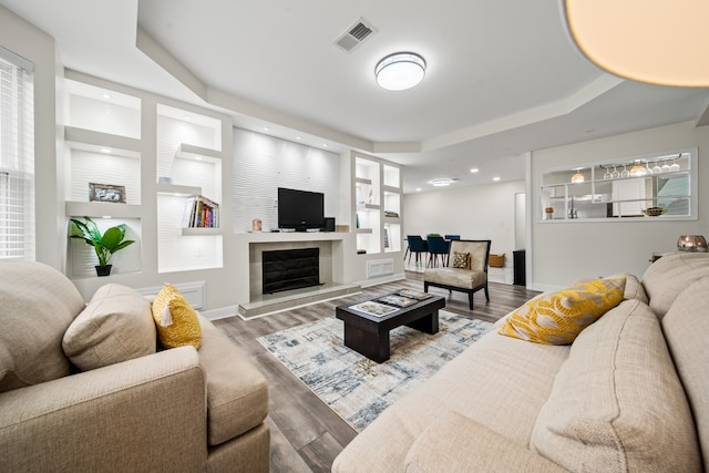 living room with a tray ceiling and hardwood / wood-style floors