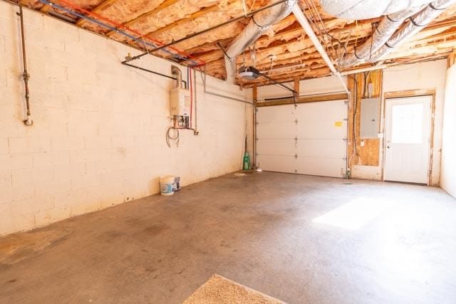 garage featuring electric panel and water heater