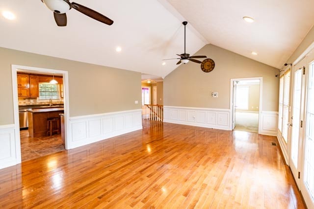 unfurnished living room with light hardwood / wood-style floors, vaulted ceiling, and plenty of natural light