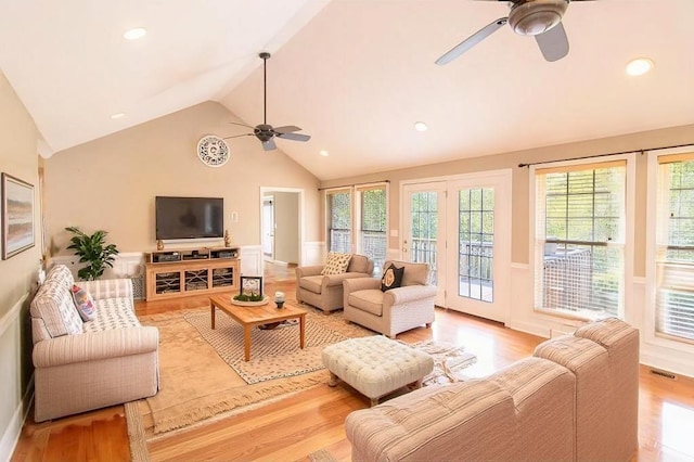 living room with ceiling fan, light hardwood / wood-style flooring, and vaulted ceiling