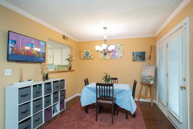 dining room with a textured ceiling, ornamental molding, hardwood / wood-style floors, and an inviting chandelier