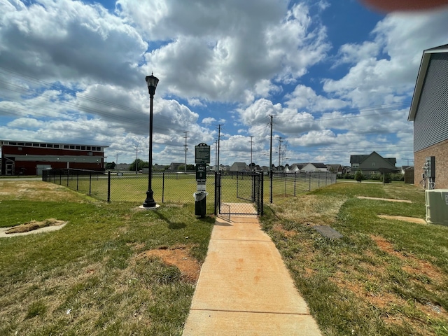 view of yard with a gate, fence, and central air condition unit