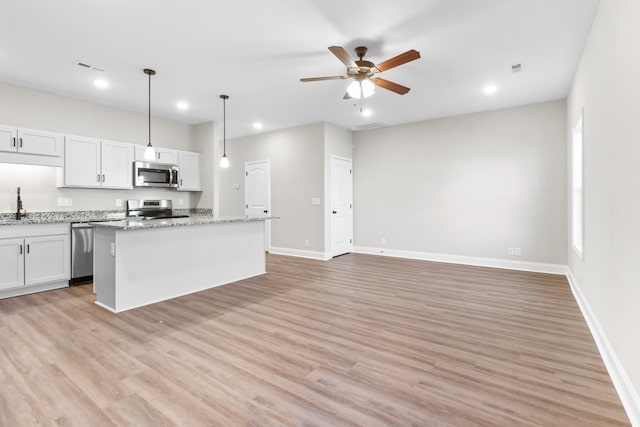 kitchen with white cabinets, light wood-type flooring, and stainless steel appliances