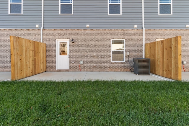 rear view of house featuring central AC, brick siding, a patio, and fence