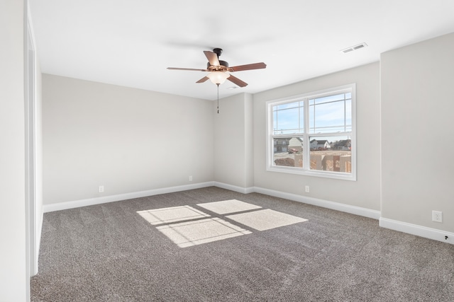 carpeted empty room featuring visible vents, ceiling fan, and baseboards