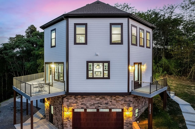 back house at dusk with a deck