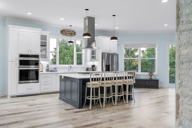 kitchen with a center island, island exhaust hood, appliances with stainless steel finishes, and a wealth of natural light