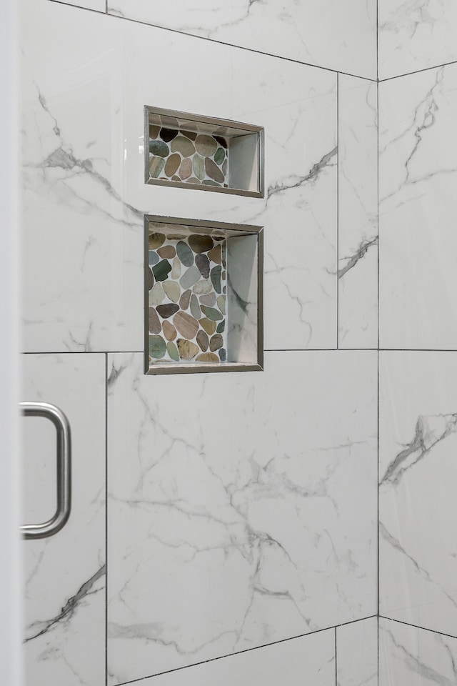 interior details featuring a tile shower