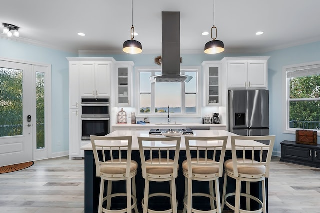 kitchen with a kitchen breakfast bar, a center island, appliances with stainless steel finishes, pendant lighting, and island range hood