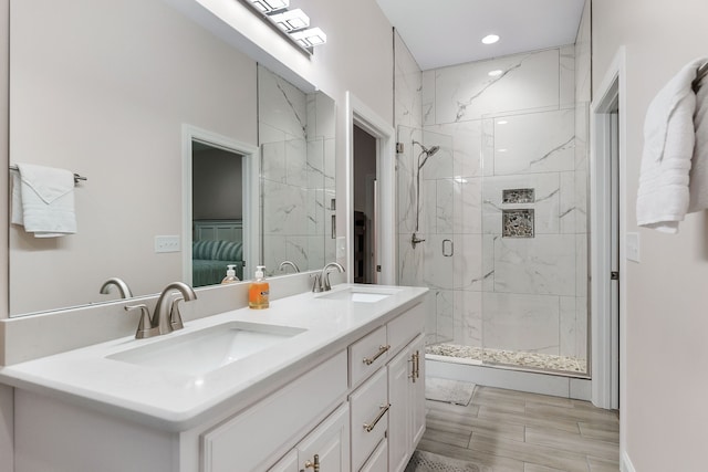 bathroom with a shower with door and vanity