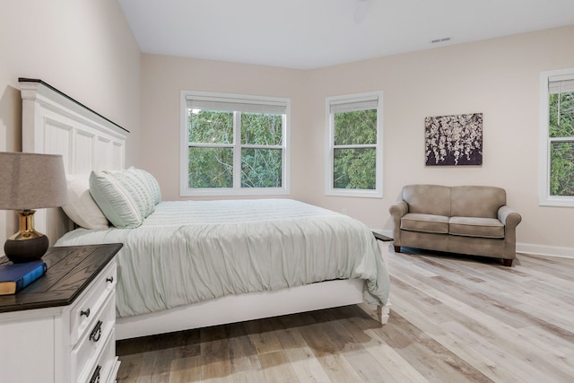 bedroom with light wood-type flooring and multiple windows