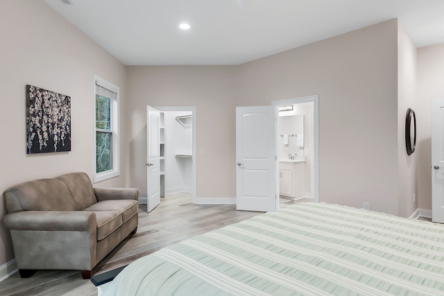 bedroom featuring a spacious closet, light hardwood / wood-style flooring, and ensuite bathroom