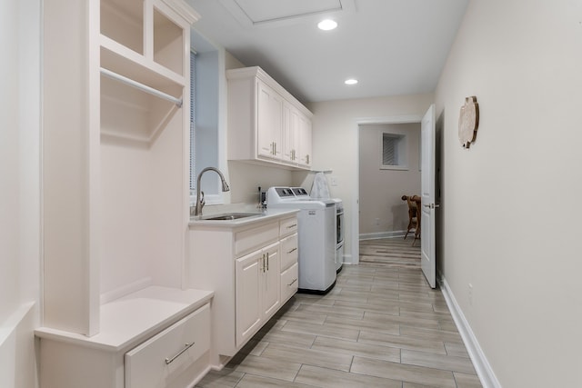 laundry area with separate washer and dryer, sink, and cabinets