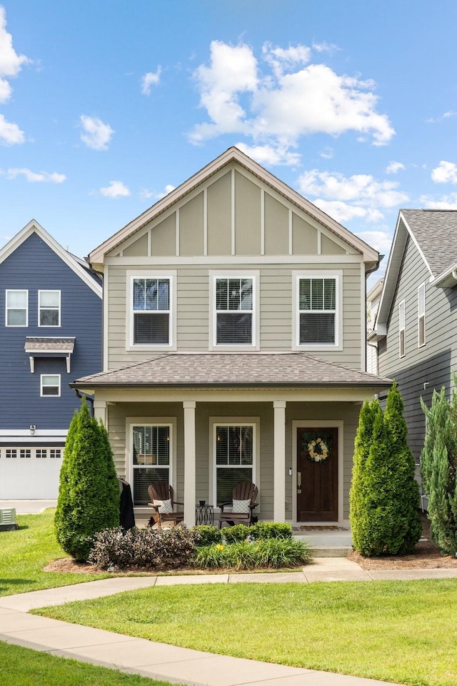 view of front facade featuring covered porch, a front lawn, and a garage