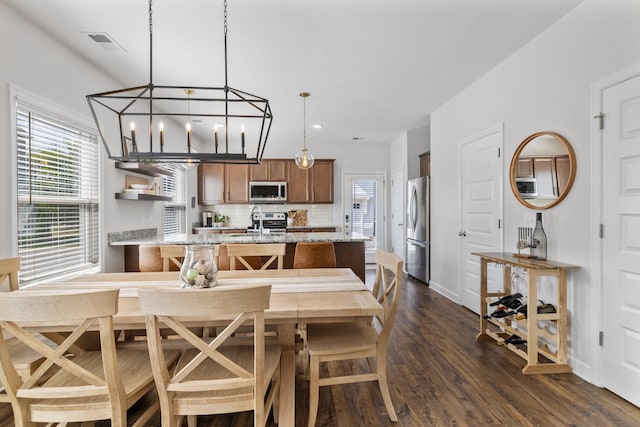 dining space with a healthy amount of sunlight and dark hardwood / wood-style flooring