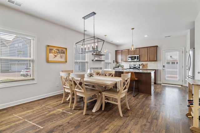 dining room with a wealth of natural light and dark wood-type flooring