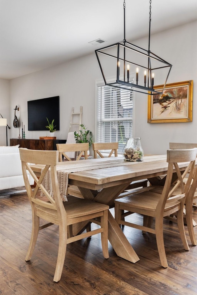 dining area featuring hardwood / wood-style flooring and a chandelier