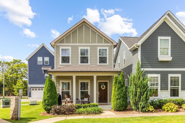 view of front of home featuring covered porch, a front yard, central AC unit, and a garage