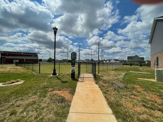 view of yard featuring central AC unit, fence, and a gate