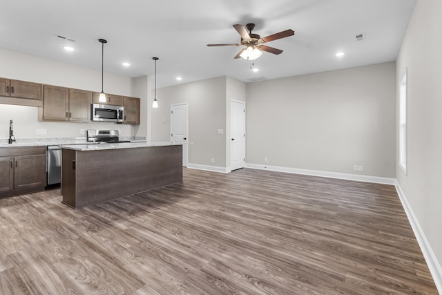 kitchen featuring ceiling fan, stainless steel appliances, a kitchen island, visible vents, and dark wood finished floors