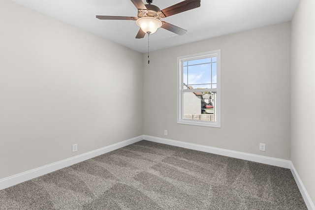 carpeted empty room with a ceiling fan and baseboards